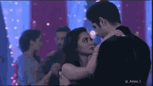 a man and a woman are hugging each other in a room