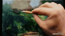 a hand is holding a brush and painting on a canvas with the words made in animatica on the bottom