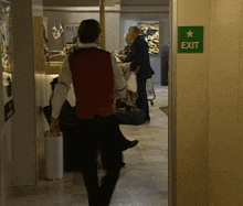 a green exit sign with a star on it is in a hallway