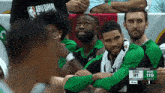 a group of basketball players are sitting in the stands watching a game