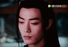 a close up of a man 's face with chinese writing on the bottom left