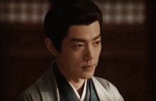a man with his eyes closed is wearing a blue shirt