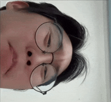 a close up of a person 's face with glasses on .