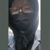 a blurry picture of a person wearing a black mask and glasses