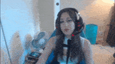 a woman wearing headphones is sitting in front of a fan and a trash can