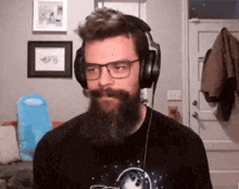 a man with a beard wearing headphones and a black shirt