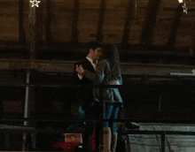 a man and a woman are kissing in a dark room with the number 12 on the ceiling