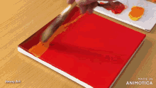 a person is painting a red canvas with a brush and the words made in animatica on the bottom