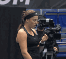 a woman wearing an adidas headband talks to a camera