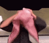 a man is holding a pink scarf over his head .