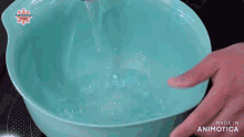 a person is pouring salt into a blue bowl of water