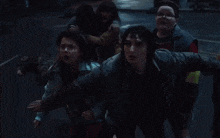 a group of people are running down a dark street at night