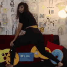 a woman is dancing on a couch with a like box in the background