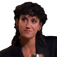 a woman with curly hair wearing a black jacket is smiling
