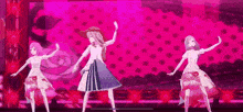 three anime girls are dancing on a stage .