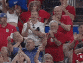 a group of people in a stadium wearing red shirts with the letter s on them