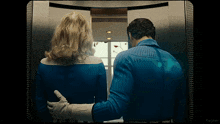 a man and woman are standing in an elevator with the word kepler on the bottom right