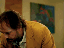 a man in a yellow jacket is looking down