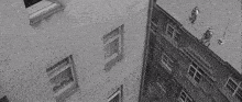 a black and white photo of a person falling from the roof of a building