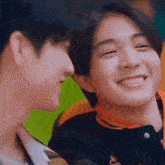 two young men are smiling at each other while looking at each other .