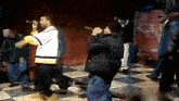 a group of men are standing on a checkered floor and one of them is singing into a microphone