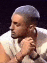 a man with a shaved head is holding a microphone and looking at the camera .