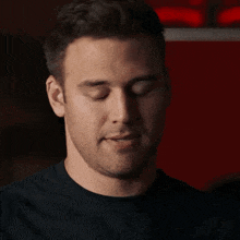 a close up of a man 's face with his hand on his mouth