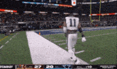 a football player wearing a number 11 jersey is running on the field