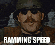 a man with a mustache wearing a helmet and sunglasses says ramming speed