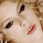 a close up of a woman 's face with makeup and rhinestones