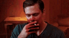 a man with blood on his face smoking a cigarette .