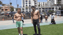 a shirtless man is standing next to another shirtless man in front of a bike van