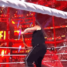 a man is wrestling in a wrestling ring with a rope around his head .
