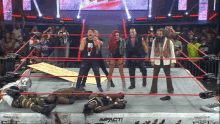 a group of wrestlers are standing in a ring with a sign that says impact on it