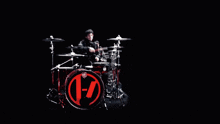 a man is playing drums in a dark room with smoke coming out of his drum set