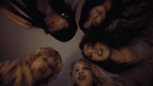 a group of women laying in a circle with their faces in the air