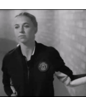 a black and white photo of a woman wearing a jacket with the letter o on it