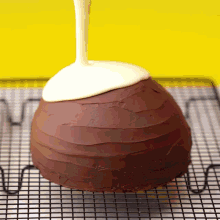 a chocolate cake with white frosting being poured over it