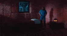 a man in a blue shirt is sitting on a bed