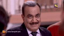 a man in a suit and tie is on a sony tv screen