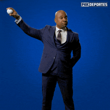 a man in a suit is walking in front of a blue background that says fox deportes on it