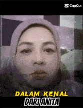 a woman wearing a hijab with the words dalam kenal dari anita above her