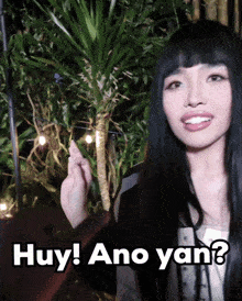 a woman with long black hair is holding a string of lights and says huy ano yan ?