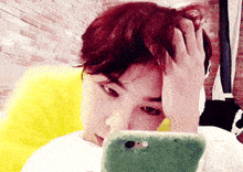 a man with red hair is looking at a cell phone