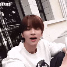 a young man wearing a white sweatshirt with the word series on the bottom