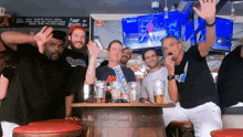 a group of men are sitting around a table with a bag of drakard