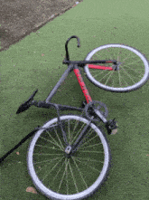 a bicycle is laying on the grass with the front wheel missing