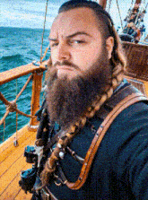 a man with dreadlocks and a beard is on a boat