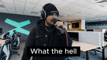 a man singing into a microphone with the words " what the hell " on the bottom