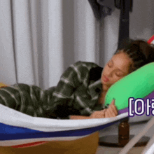 a woman is sleeping in a hammock with a green pillow and a sign that says [ off ] in the corner